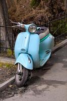 scooter azul claro vintage de estilo retro se encuentra cerca de un callejón. foto