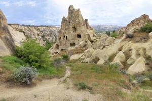 An unearthly landscape and a view of ancient dwellings in ancient cone-shaped caves in the valleys of Cappadocia photo