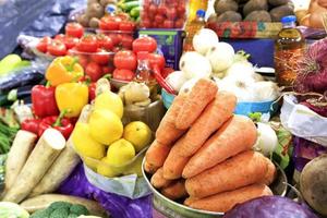 zanahorias, tomates, cebollas, pimientos y otras verduras, tubérculos y limones, aceite de girasol se venden en los estantes del mercado. foto