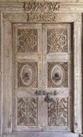 Puertas antiguas de madera con manijas de metal y una cerradura en el medio
