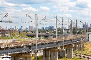 A powerful multi-level railway network with a bend and a flyover against the backdrop of a cityscape. photo