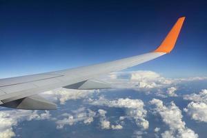 Wing of a flying airplane in a blue sky photo