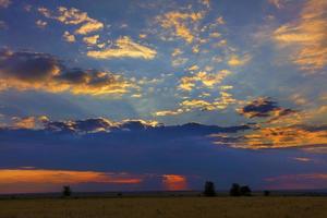 Fiery reddish sunset over a field in a rural evening landscape photo