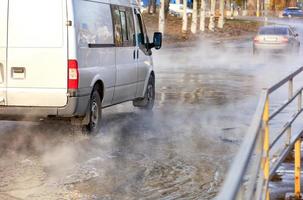 The road flooded with hot water after the breakthrough of the city heating main. photo