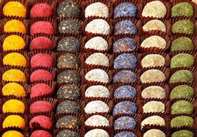 Handmade energy balls filled with various seeds, in brown paper baskets, in even rows. photo
