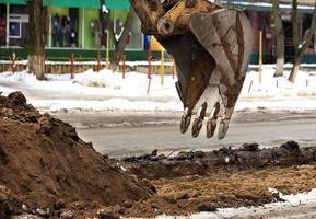 Repair of the roadway with an excavator in winter. photo