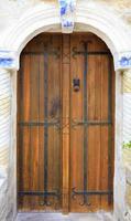 Las antiguas puertas de madera en el pasaje arqueado están cubiertas con rejas de hierro forjado. foto
