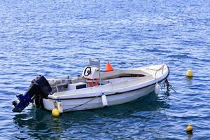 un barco a motor está anclado en las aguas cristalinas del mar jónico. foto