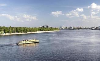 Embarcación de recreo va a lo largo del río Dnieper en un día soleado foto