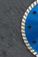 fragmento de una rueda de corte de diamante azul sobre un fondo de granito gris. copie el espacio. imagen vertical. foto