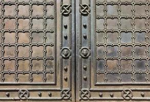 Puertas de metal antiguas cubiertas con rejilla de hierro forjado y patrón estampado. foto