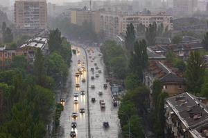 Reflection of headlights on a wet road from passing cars in heavy rain in residential areas and streets of the old city. photo