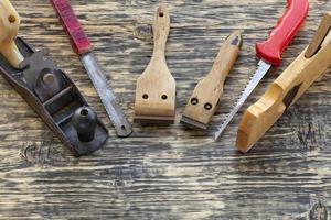 Antiguas herramientas de carpintería se encuentran en una mesa de madera.