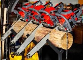 Las motosierras rojas están atascadas en un tronco. concepto de herramienta de jardín profesional.