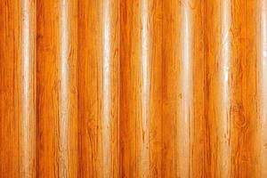 A wooden wall of smooth, orange-lacquered tree trunks lined up vertically. photo