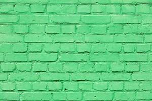 A very old brick wall completely painted with green paint. photo