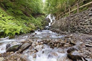 Cascade waterfall Shipit on a fast mountain river between the hills of the Carpathian Mountains. photo