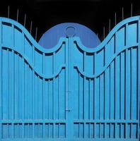 Exemplary metal gate-fence with outdated bright blue paint. Abstract texture background. photo