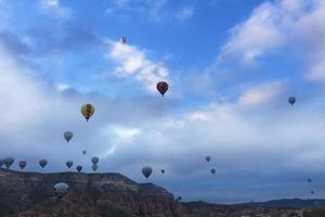 Dozens of balloons fly over the valleys in Cappadocia photo