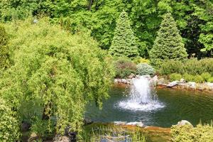 Decorative pond with a fountain in a beautiful summer park. photo