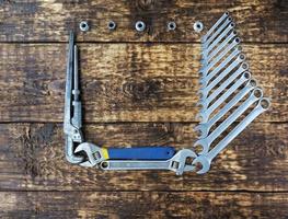 A set of combined keys and old adjustable keys on an old wooden background with a place for copy space photo