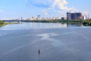 un hermoso paisaje urbano del río dnipro en la ciudad de kyiv en el horizonte. foto