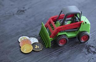 Toy tractor rakes coins crypto currency photo