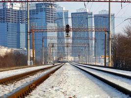 Winter cityscape, electric train moving on rails, central perspective. photo