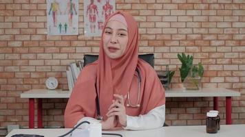 Portrait of beautiful female doctor, beautiful Muslim in uniform with stethoscope, smiling video chat and looking to camera in hospital's clinic. Person who has expertise in professional treatment.