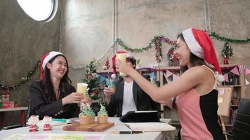Happiness Business colleagues team celebrating, raising glasses and cheerful while meeting at office workplace before company holidays, decorated for Christmas festival and New Year's Day party. video