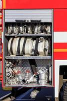 Las mangueras, válvulas y grúas contra incendios están ubicadas en el compartimiento de carga de un camión de bomberos equipado.