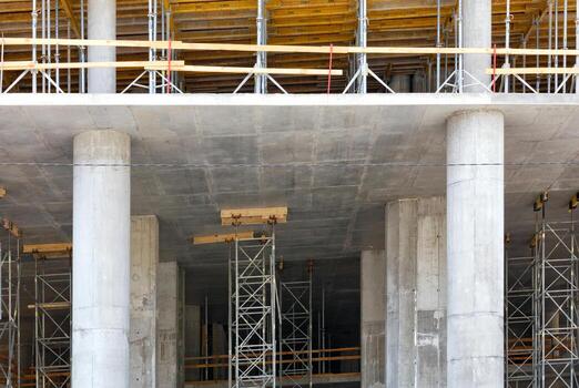 The concept of construction of new buildings using a monolithic-frame method, concrete columns with scaffolding, formwork and metal supports. photo