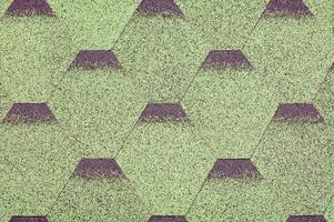 el fondo y la textura de un techo hecho de placas de betún verde en forma de diamante. foto