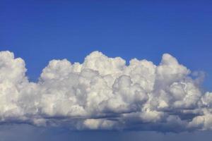 gran nube blanco-gris se condensa en una nube lluviosa en el cielo azul, primer plano. foto