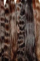 Bundles of healthy natural hair of various chocolate shades, close-up photo