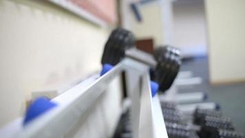 Bodybuilder man doing exercises with dumbbells in the Gym video