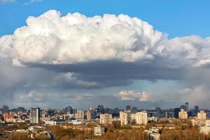 A large white-gray cloud hung over the city and was illuminated by the spring sunbeams. photo