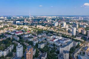 Aerial photography, summer day of urban residential neighborhoods with a television tower on the horizon in a blue haze. photo