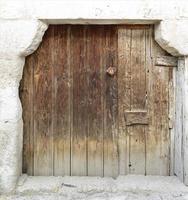 Antiguas puertas de madera antiguas trapezoidales con una cerradura de madera en el medio