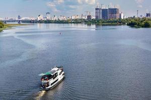 A river tram carries tourists along the Dnipro River along the left bank of Kyiv, top view. photo