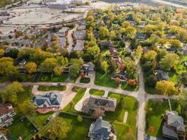 Aerial view of residential neighborhood in Northfield, IL. Lots of trees starting to turn autumn colors. Large apartment complexes and residential homes.  Meandering tree lined streets.