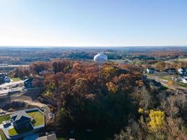 Aerial view of Eau Claire, Wisconsin, water tower.  Fall foliage present in landscape.  Residential area seen.   Industrial area seen in far top.  Blue sunny sky on fall day. photo