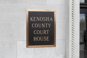 Exterior sign of Kenosha County Court House.  Posted on white marble wall near entrance.  Outlined in gold with black background. photo