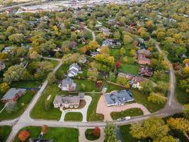 Aerial view of residential neighborhood in Northfield, IL. Lots of trees starting to turn autumn colors. Large residential homes, some with solar panels. Meandering streets photo