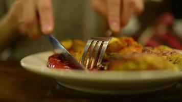 Kartoffel auf einem Teller mit Messer und Gabel schneiden video