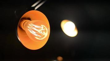 uma lâmpada incandescente com uma espiral luminosa em um quarto escuro video