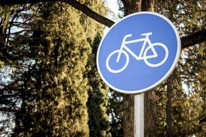 Señal de carretera de bicicleta con thees verde en el fondo. foto