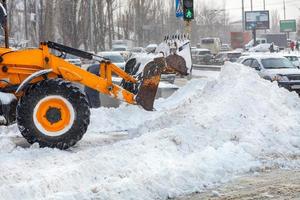 fragmento de vehículos municipales que despejan la calzada de una calle de la ciudad de una abundancia de nieve. foto