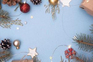 Christmas flat lay. Concept photo Christmas gift, New Year. Fir tree and golden twigs, decorations, garlands on a blue background. Copy space