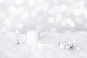 Podios de maquetas para cosméticos en la nieve con bayas decorativas sobre fondo bokeh foto